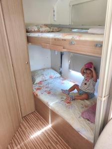 埃拉特沙漠大蓬车露营地的坐在双层床中间的小孩