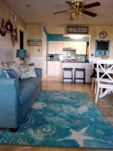 阿兰瑟斯港Vista del Mar 505BH的一间带蓝色沙发的客厅和一间厨房
