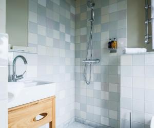 韦斯特兰Mimosa Suites的带淋浴和盥洗盆的浴室