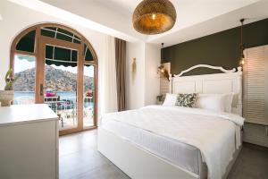 博德鲁姆Liman Hotel Gümüslük - Adult Only的卧室设有白色的床和大窗户