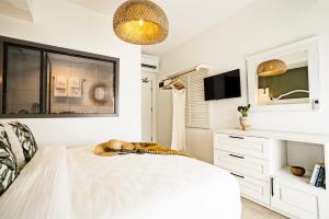 博德鲁姆Liman Hotel Gümüslük - Adult Only的一间白色卧室,配有床和电视