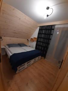 布科维纳-塔钱斯卡Bajka w Gliczarowie的木制客房内的一间卧室,配有一张床