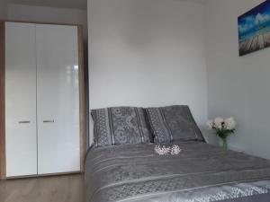 科沃布热格Mazowiecka Park的一间卧室配有一张带灰色床单和镜子的床