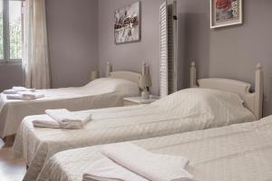 干尼亚Narkissos 'SUPERB'的一间设有三张床的客房,备有毛巾