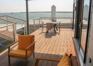 格吕桑Les Ilots de Gruissan的船上的阳台配有桌椅