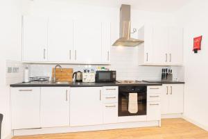 伦敦伦敦中心公寓 - 位置优越 的白色的厨房配有白色的橱柜和微波炉