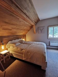 格舍嫩Jupi Hüsli的一间卧室设有一张带木制天花板的大床
