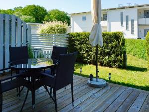 维斯比4 person holiday home in Visby的庭院配有桌椅和遮阳伞。