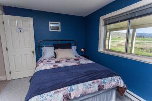 坎卢普斯奥弗兰德住宿加早餐旅馆的蓝色的卧室设有床和窗户