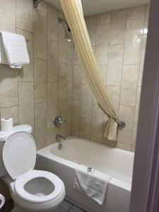 西孟菲斯豪华旅馆的浴室配有卫生间和带淋浴的浴缸。