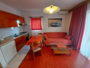 巴斯卡Apartments & Rooms Nensi的客厅配有红色的沙发和桌子