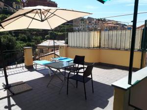 马纳罗拉Il Cavalluccio Marino的庭院配有桌椅和遮阳伞。