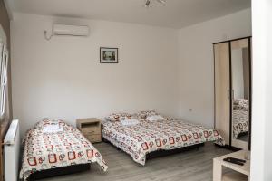 巴伊纳巴什塔CITY APARTMENT BB的一间卧室配有两张床和镜子