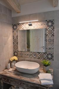 阿尔贝罗贝洛Dimore Barsento的一间带大型白色浴缸和镜子的浴室
