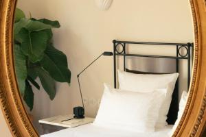 圣特罗佩Hotel la Ponche的床上的镜子和白色枕头