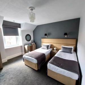 Newmacher尼马夏尔酒店的一间卧室配有两张床和吊灯。