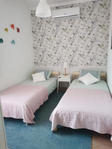 塞图巴尔Casa da Ti Bia的花卉壁纸客房内的两张床