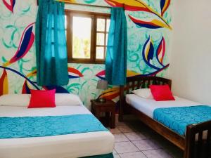 南圣胡安HC丽日酒店的色彩缤纷的壁纸客房内的两张床