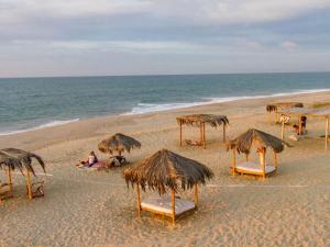 索里托斯竹苑酒店的海滩上设有椅子和草伞,还有大海