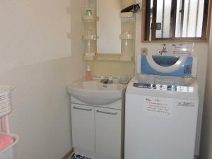 五岛马里亚热私人住宅旅馆的一间带水槽和洗衣机的小浴室