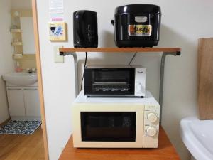 五岛马里亚热私人住宅旅馆的厨房内的架子上配有微波炉和烤面包机烤箱