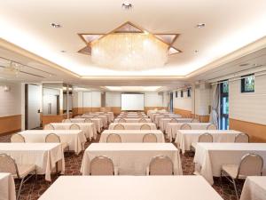 广岛HOTEL MYSTAYS Hiroshima Peace Park的宴会厅配有白色的桌椅