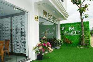 岑山Khách sạn Melanta Hotel - FLC Sầm Sơn的建筑窗户上有鲜花的商店