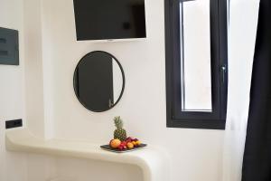 卡马利国王套房酒店的浴室水槽设有镜子和一盘水果