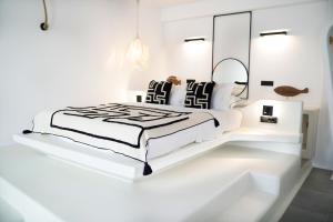 卡马利国王套房酒店的白色卧室配有床和镜子