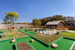 TouwsrivierAquila Private Game Reserve & Spa的一座带两个果岭和一个建筑的高尔夫球场