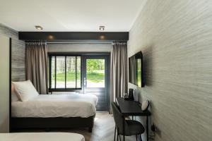 卢特伦Hotel de Werelt的一间卧室配有一张床、一张书桌和一个窗户。