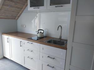 斯蒂格纳Apartament z tarasem的厨房配有白色橱柜和水槽