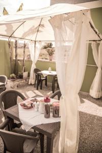 乌真托梅塞皮亚住宿加早餐旅馆的庭院里的一张带白色天篷的桌子
