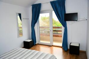 茹里洛夫卡Pensiunea Codalb的一间卧室配有床和蓝色窗帘的窗户