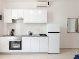 普利兹巴Apartments K & N的白色的厨房配有水槽和冰箱