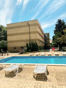 内塞伯尔Hotel Kamenec Budget的一座带椅子的游泳池和一座建筑