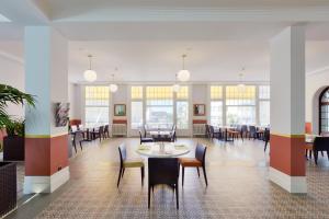 蒙特勒J5 Hotels Helvetie & La Brasserie的用餐室设有桌椅和窗户。