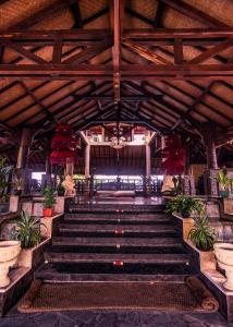 罗威那努格拉罗维纳海景假日温泉酒店的一座种植盆栽植物的建筑里,有一套楼梯