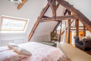 迪南L'Auberge du Coignet的卧室配有一张床铺,位于带木梁的房间