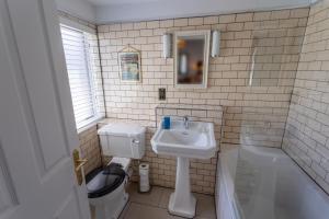韦茅斯司马格乐旅馆的浴室配有盥洗盆、卫生间和浴缸。