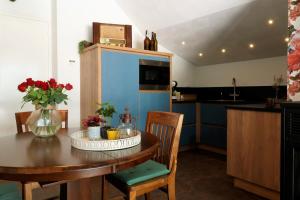 巴克瑟姆B&B Bergheide的一间带木桌的厨房和一间带蓝色橱柜的厨房