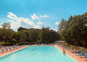 圣皮耶罗阿谢韦木吉罗维尔德营地村酒店的一座带椅子和人手的大型游泳池
