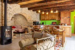 ColombièsLa Maison de Caroline的带壁炉的客厅和带绿色墙壁的厨房。