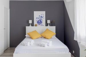 维勒班Nice studio with balcony and parking in Villeurbanne near Lyon - Welkeys的一间卧室配有白色床和黄色枕头