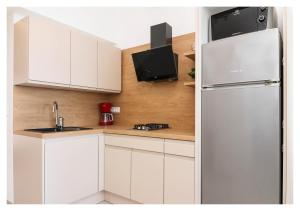 普利莫顿Apartment Jerko 2的厨房配有白色橱柜和冰箱。
