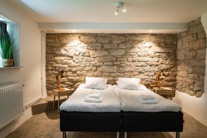 维斯比布雷达布利克酒店的一间卧室设有石墙和一张床