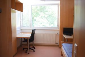 林茨城市索维亚酒店的小房间设有书桌和窗户