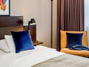 汉诺威汉诺威迈迪卡公园美居酒店的配有一张床和一把椅子的酒店客房