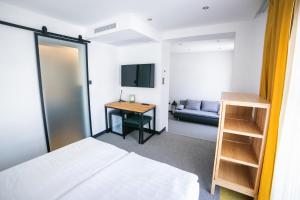 陶波尔曹加布里埃拉酒店的一间卧室配有一张床、一张书桌和一台电视。