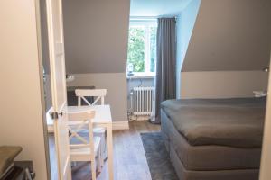 赫尔辛堡Continental Apartment Hotel Helsingborg的卧室配有1张床、1张桌子和1把椅子